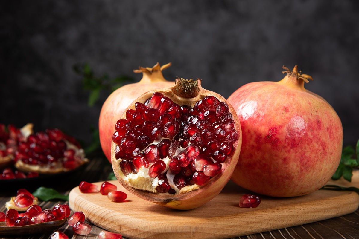 Open,Pomegranates,,And,Pomegranate,Seeds,On,Wooden,Table.