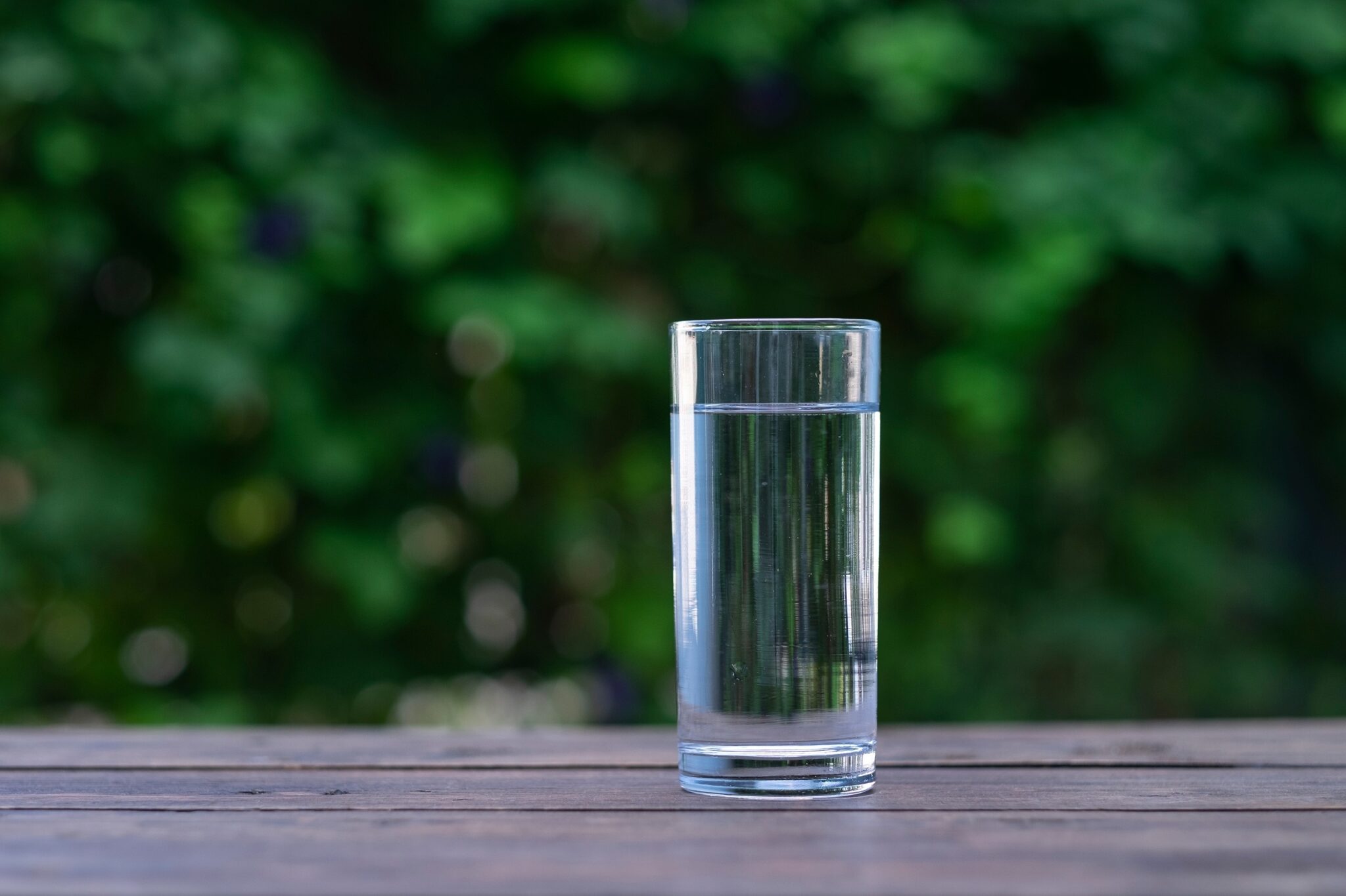 Clear,Drinking,Glass,On,The,Table,,Gree,Background