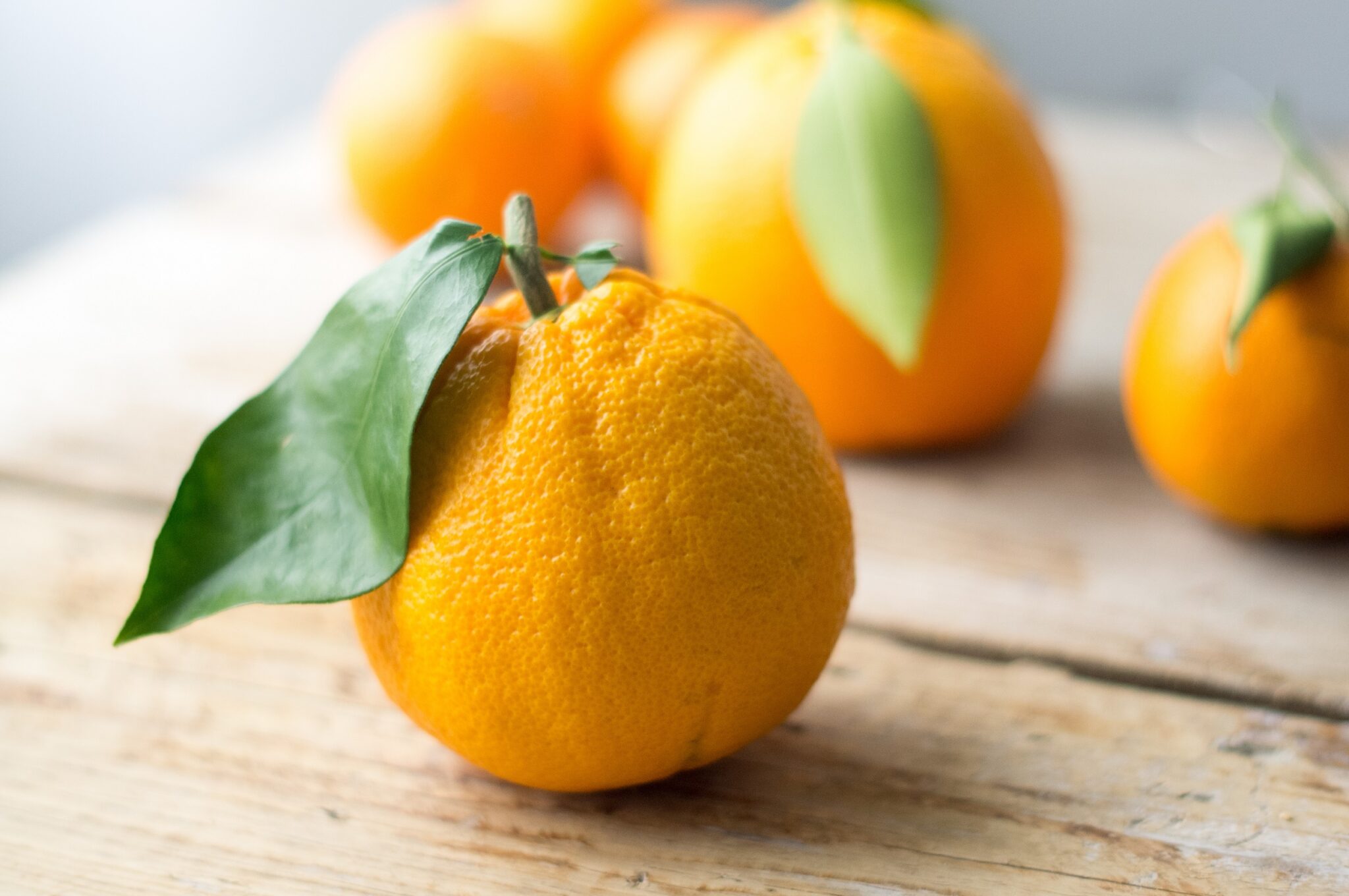 Oranges,With,The,Leaves,Isolated,On,The,Wooden,Table