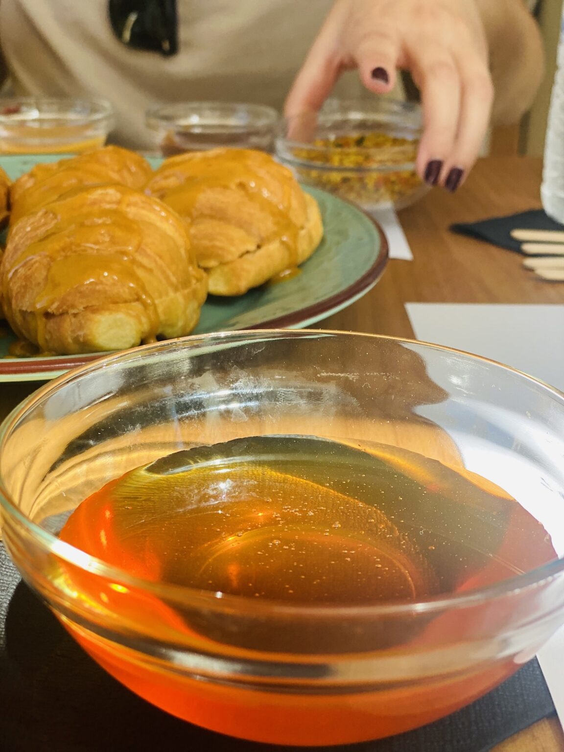a bowl of liquid next to a plate of croissants