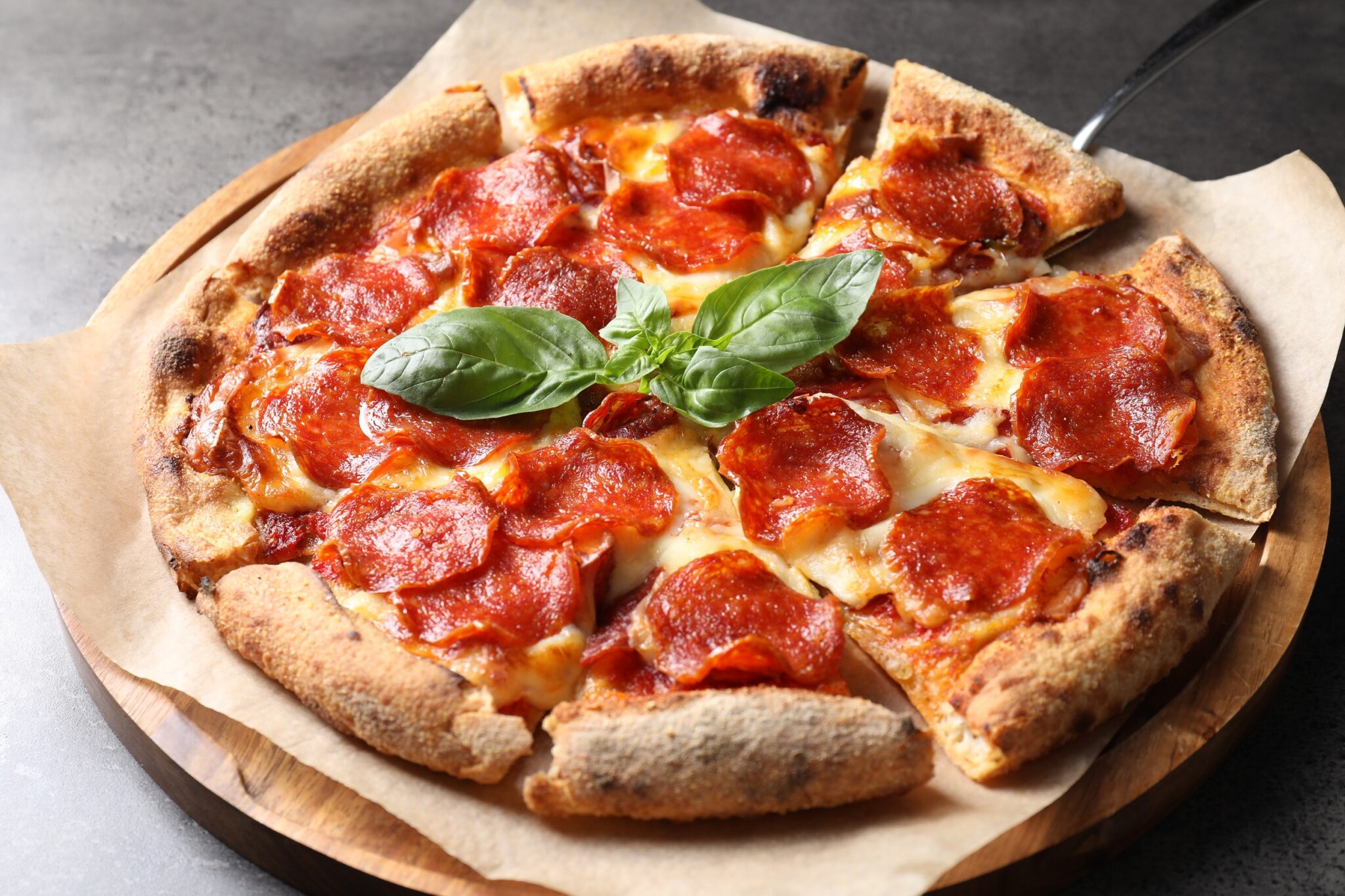 Tasty,Pepperoni,Pizza,With,Basil,On,Grey,Table