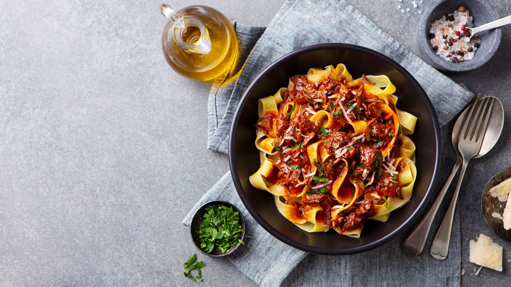 Pasta,Fettuccine,With,Beef,Ragout,Sauce,In,Black,Bowl.,Grey