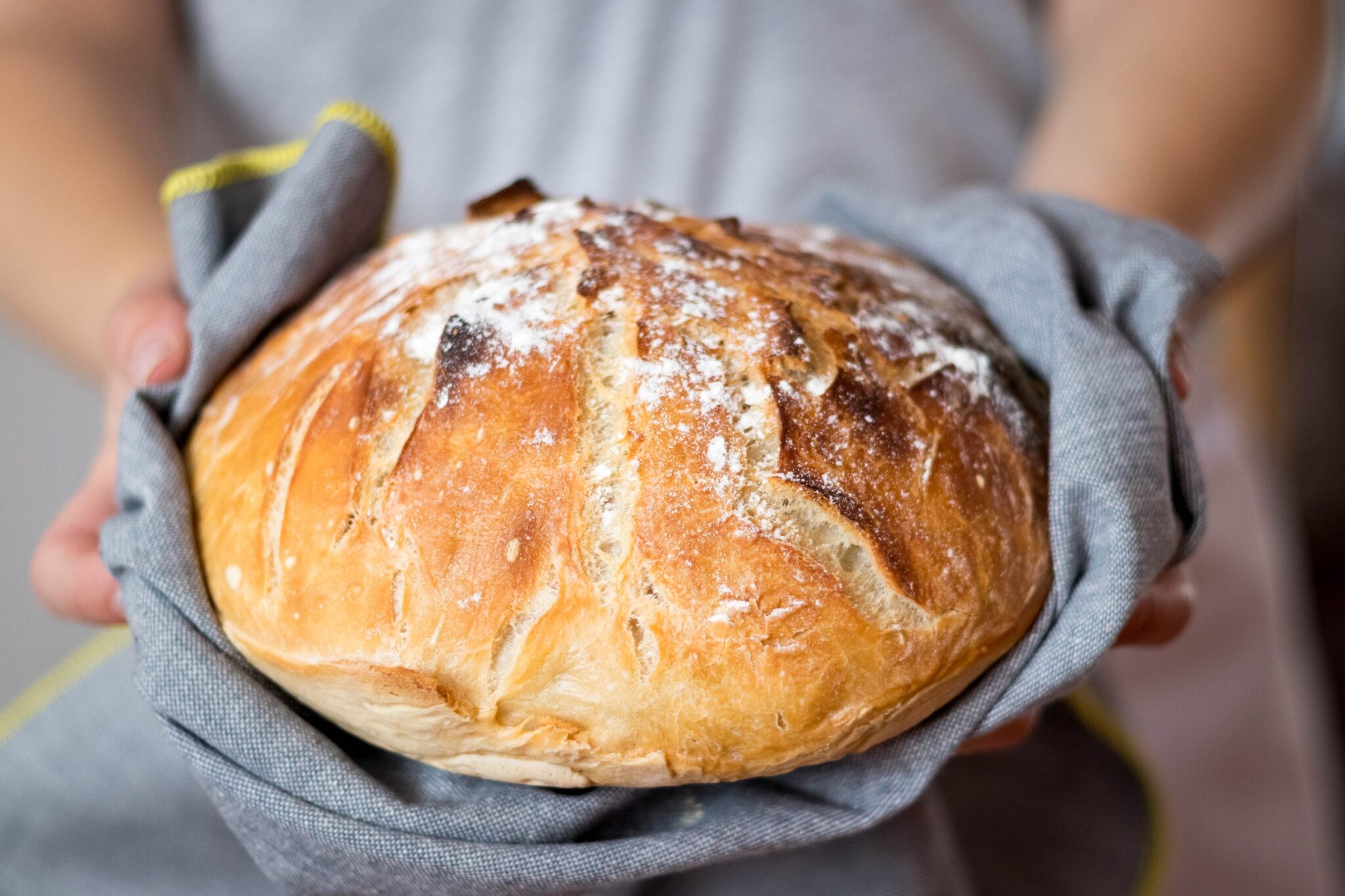 Closeup,Of,Fresh,Rustsic,Bread,In,A,Woman’s,Hand