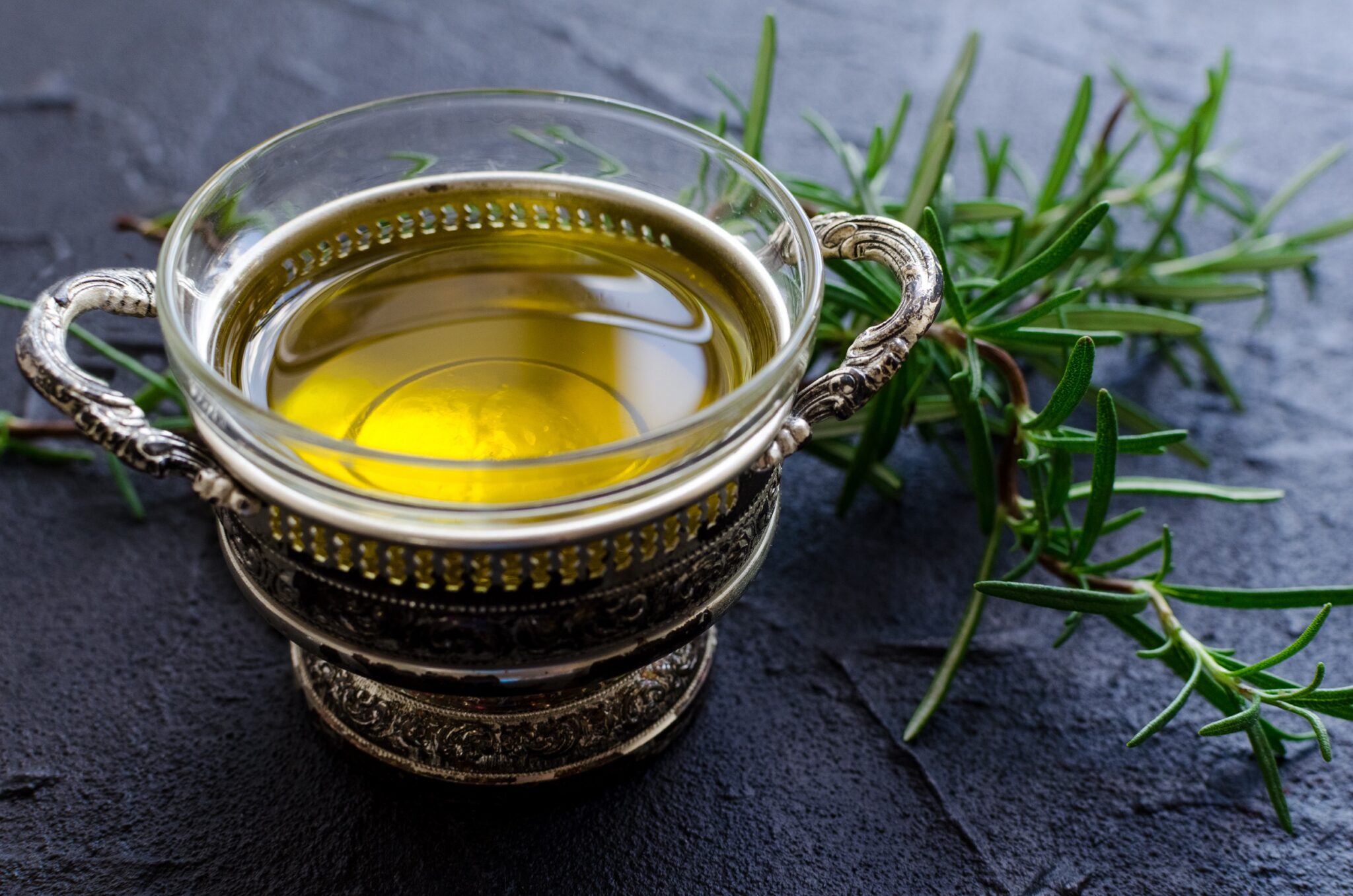 Rosemary,And,Olive,Oil,On,Dark,Stone,Table.,Herbs,And