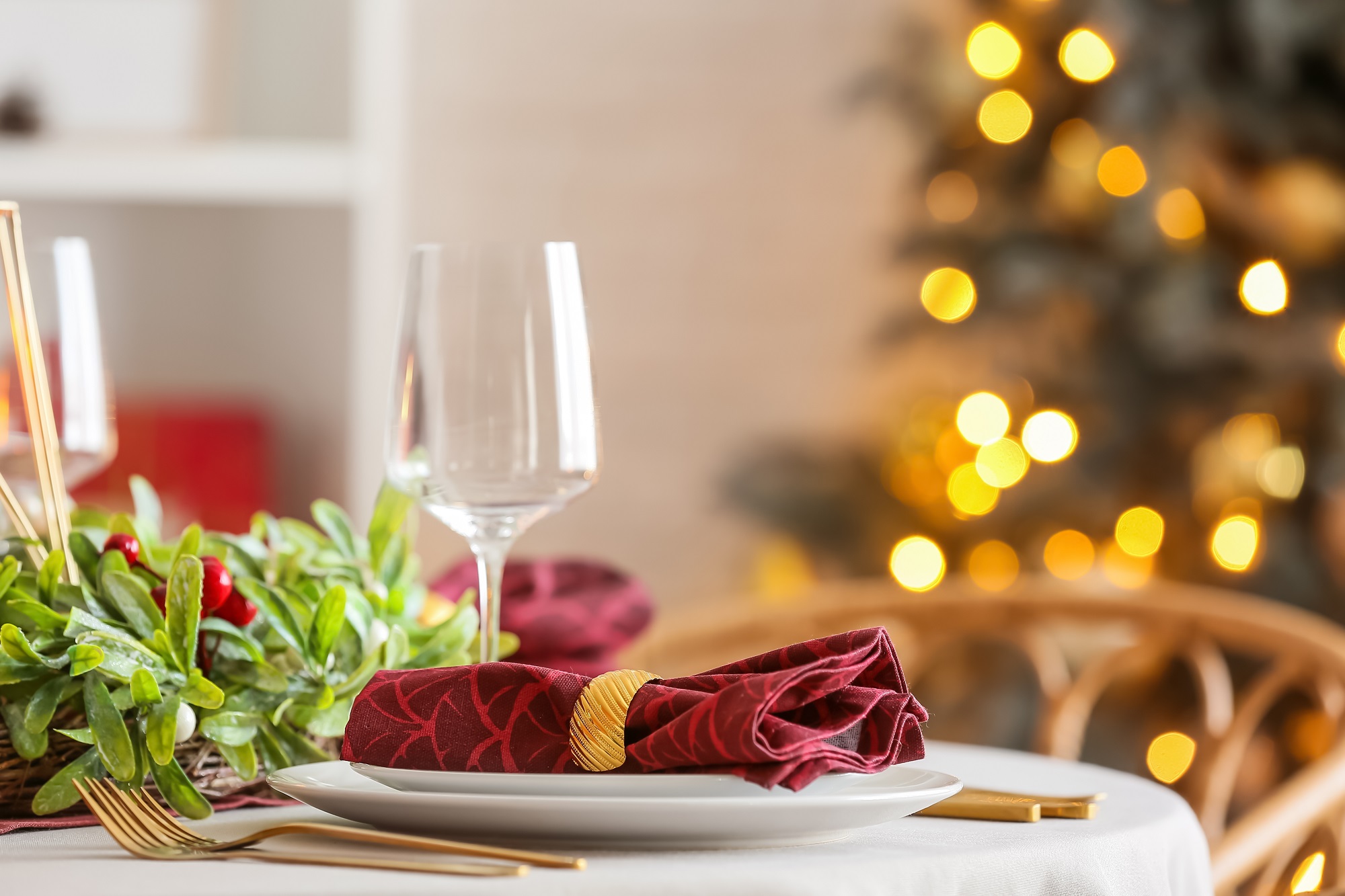 Christmas,Table,Setting,With,Mistletoe,Wreath,In,Dining,Room,,Closeup