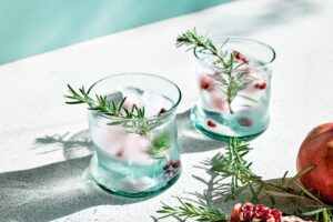 Pomegranate,Gin,Fizz,Cocktail,With,Sparkling,Wine,,Rosemary,And,Ice.