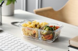 Container,With,Tasty,Food,,Keyboard,And,Books,On,White,Wooden