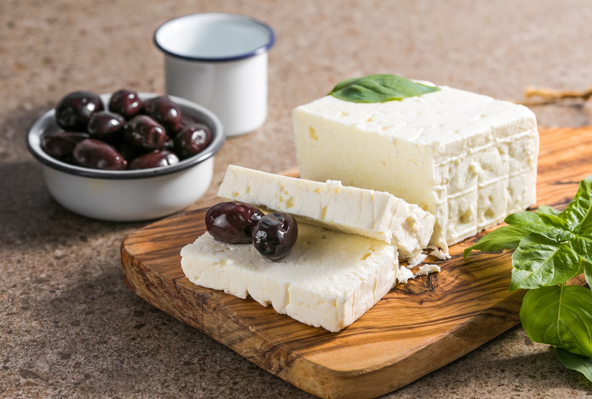 Feta,Cheese,With,Olives,And,Basil,On,A,Bamboo,Chopping