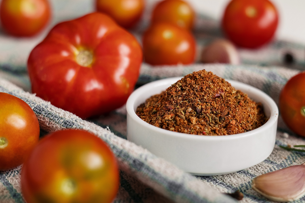 Tomato,Powder,In,A,White,Bowl,With,Fresh,Tomatoes,On