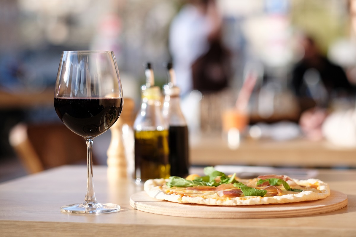 Pizza,And,Glass,Of,Red,Wine,In,Outdoor,Restaurant