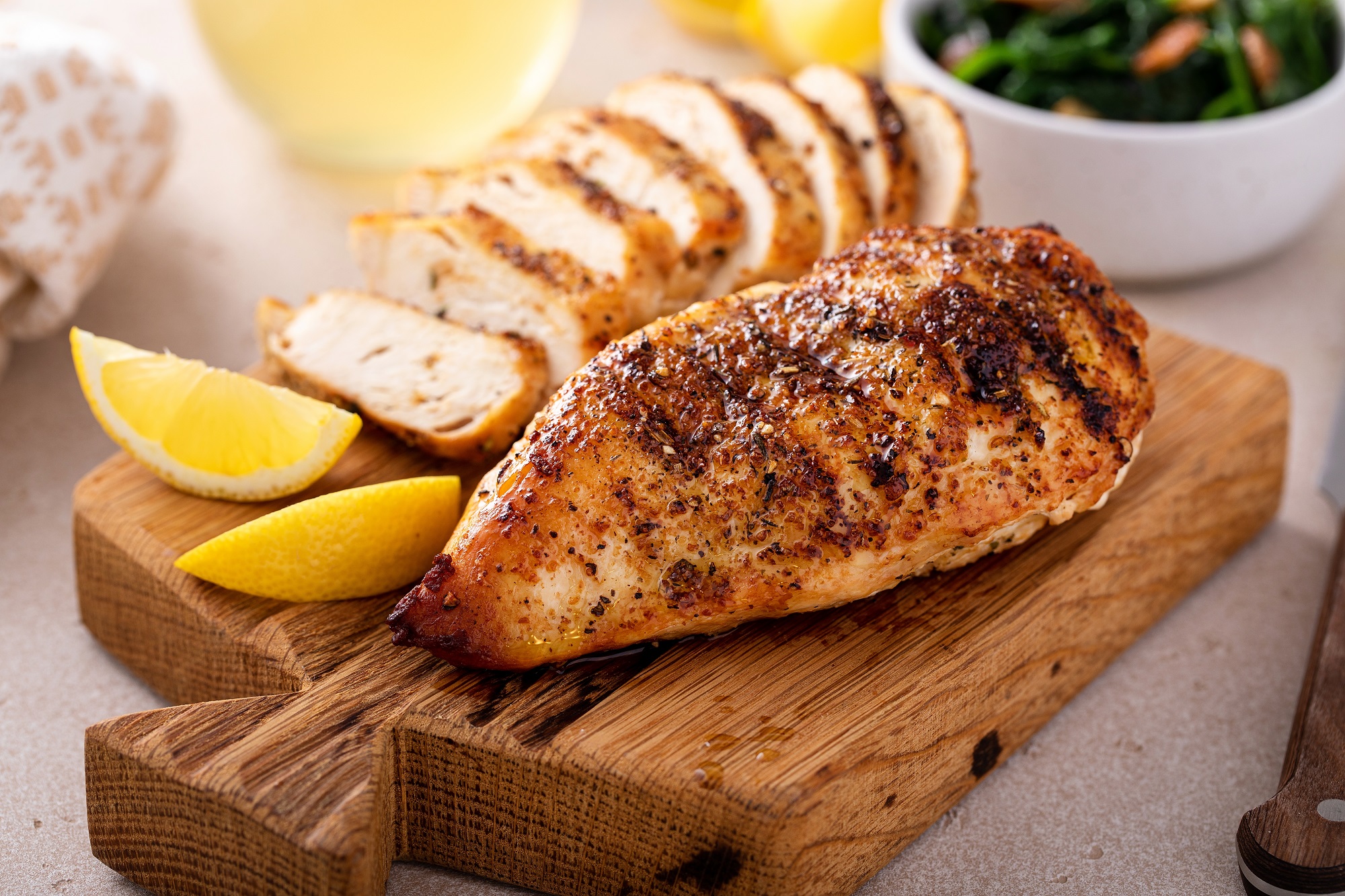 Grilled,Chicken,Breast,Whole,And,Sliced,On,A,Cutting,Board